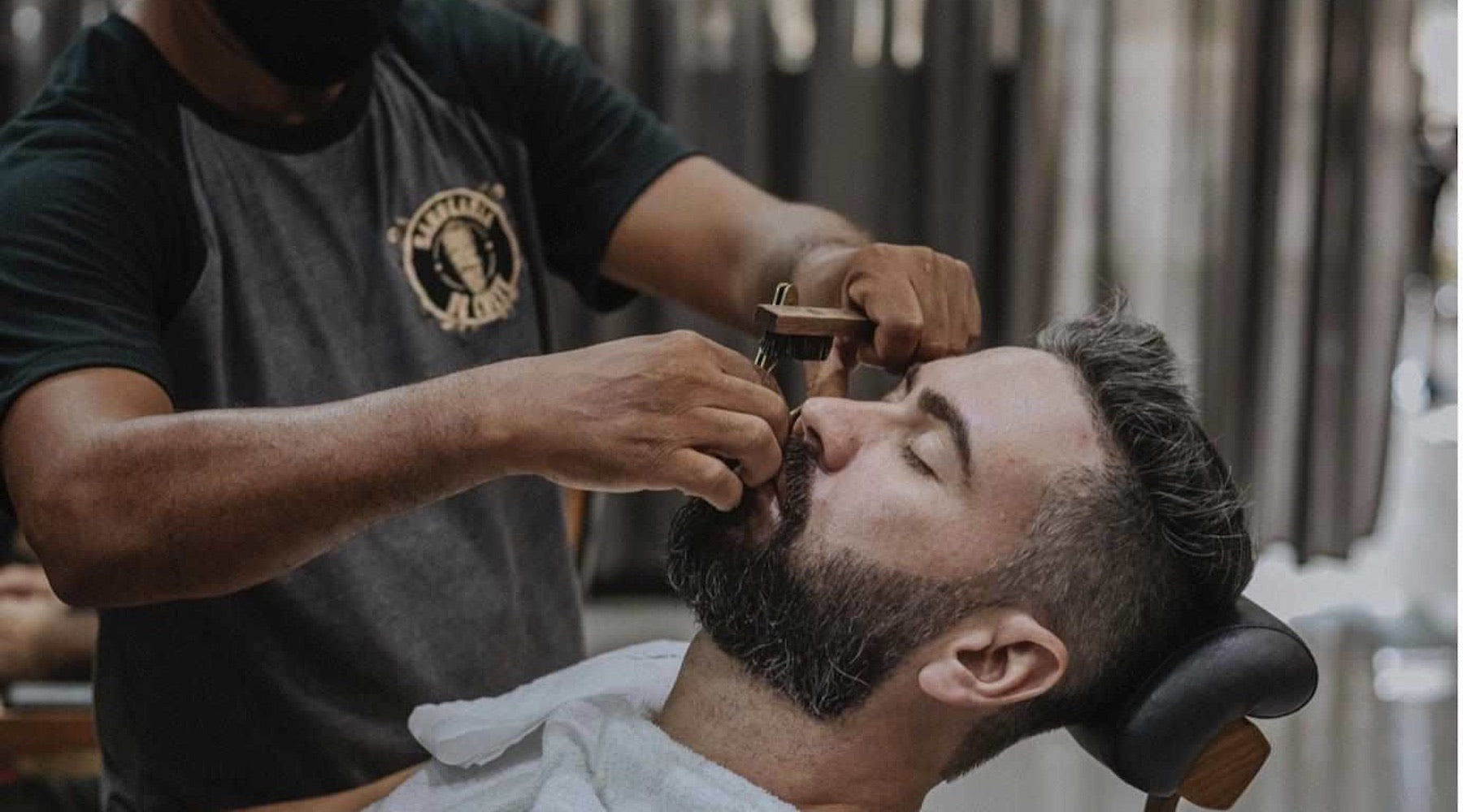 man having his beard trimmed in a barber shop