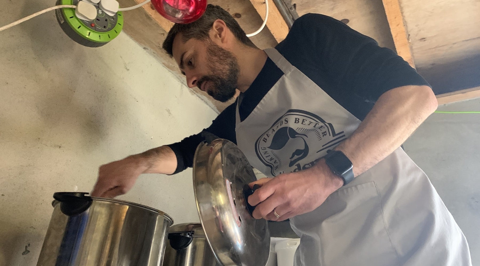 bearded man in Beardsmith apron stirring a vat of beard shampoo