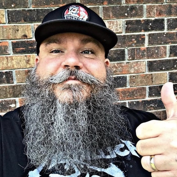 Happy guy with grey beard and a cap giving a thumbs up